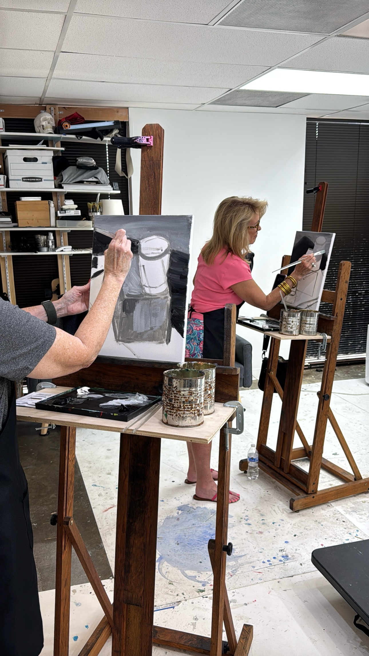 Students painting a still life in acrylic during class, each at their own easel.
