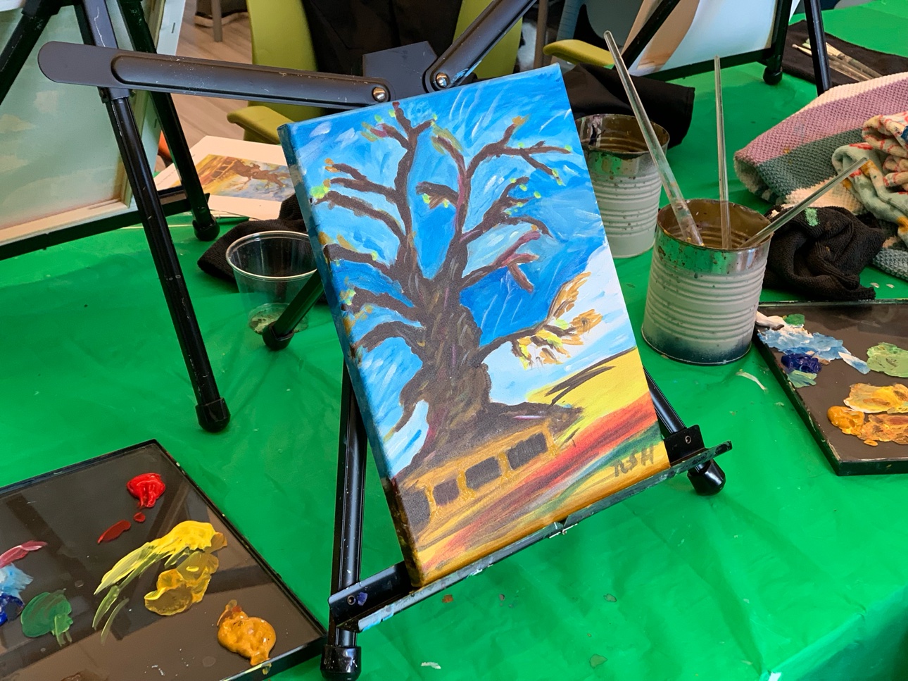 A finished tree painting on a table easel at the end of a senior painting workshop.